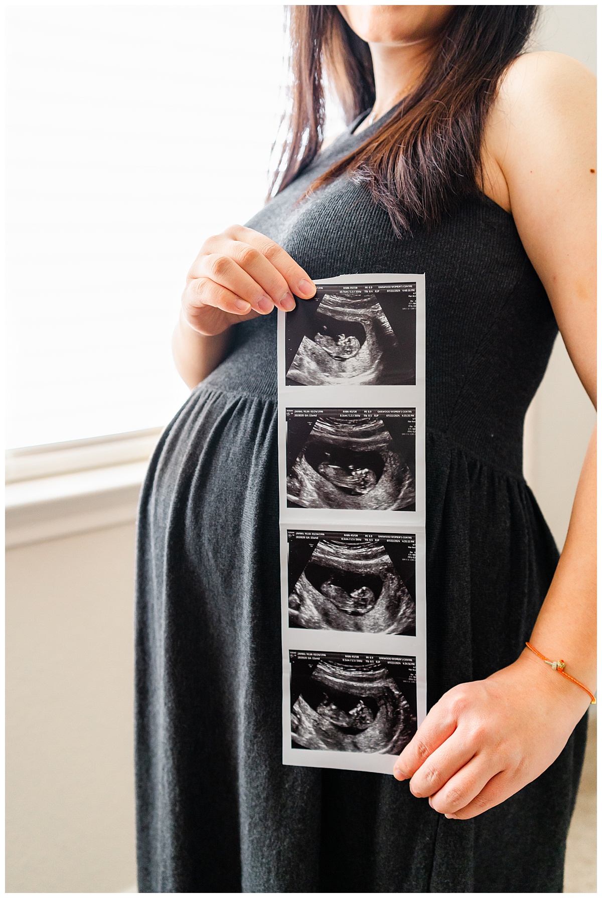 a pregnant woman holds an ultrasound picture against her belly in this close-up shot taken by an Austin maternity photographer