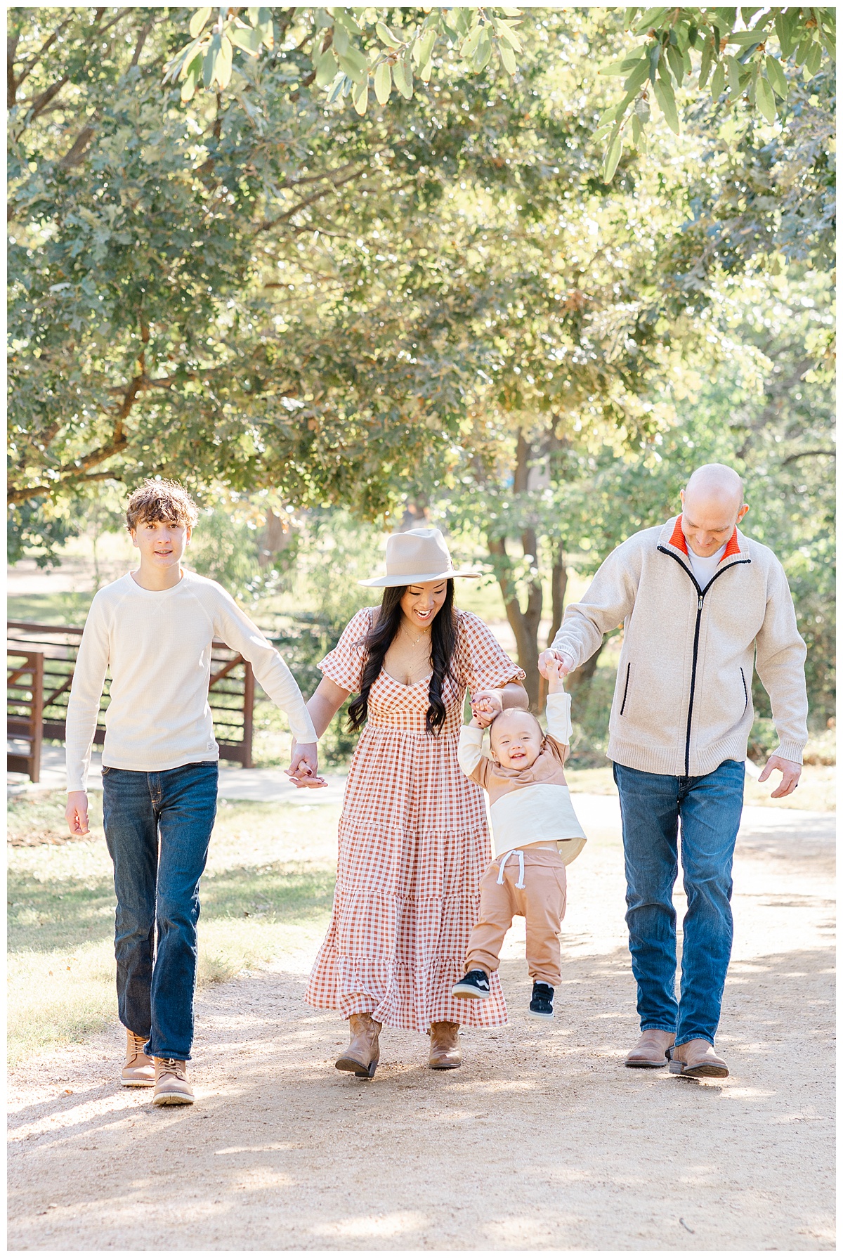 a family of four walks down a sandy path at Katherine Fleischer Park in this candid shot taken by an Austin Family Photographer