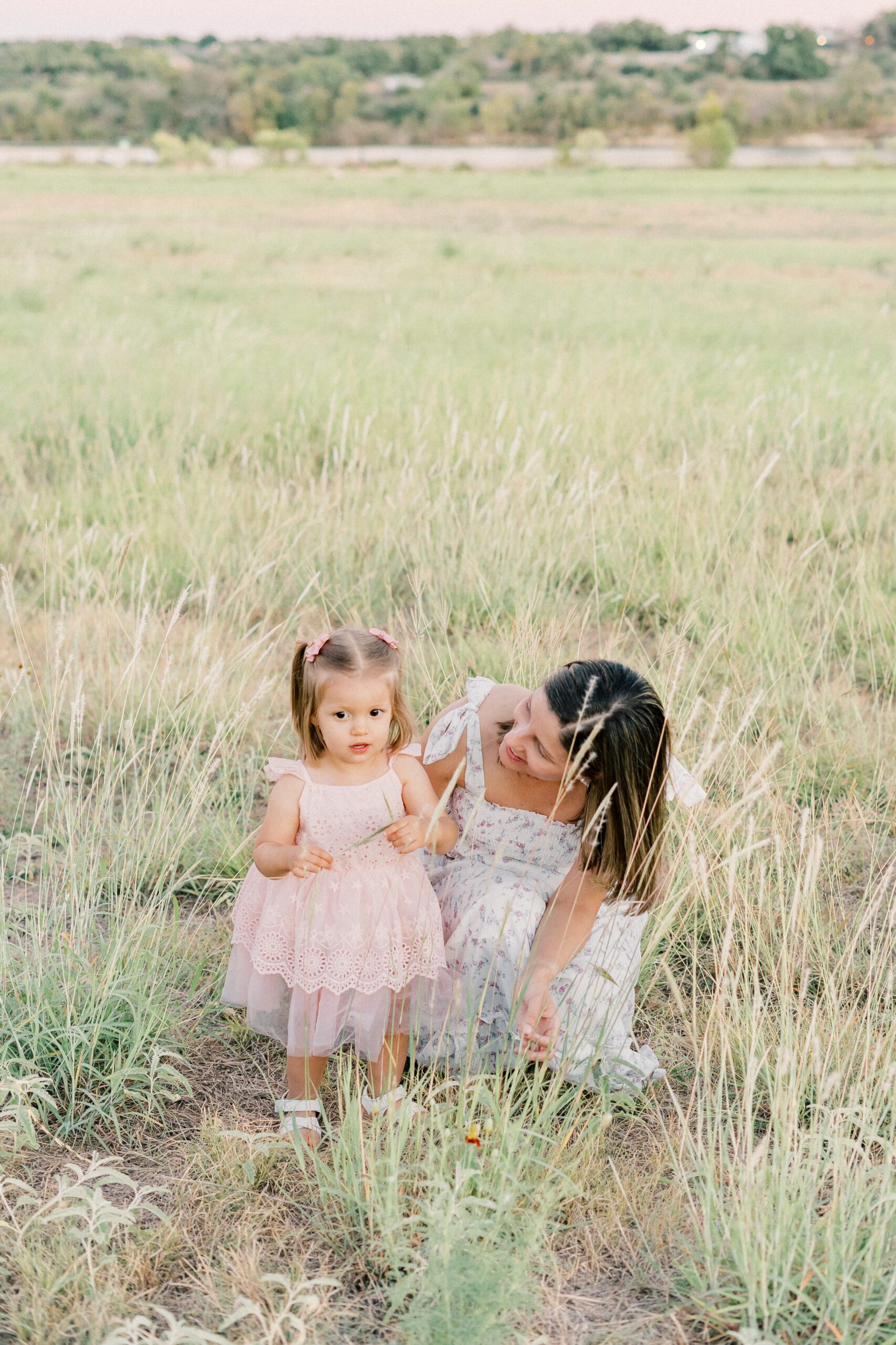 a mother and daughter stand in a field of tall grass at Brushy Creek Lake Park in this tender shot captured by an Austin Photographer.