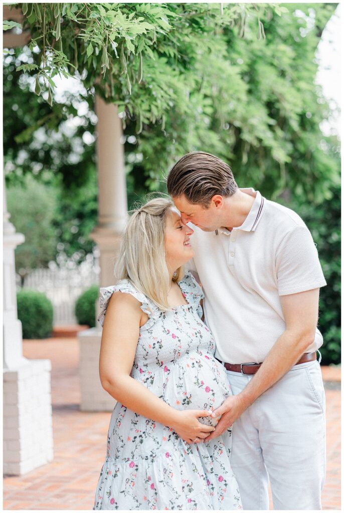 A pregnant wife and her husband go nose to nose in this maternity photo taken at the Woodbine Mansion in Round Rock.