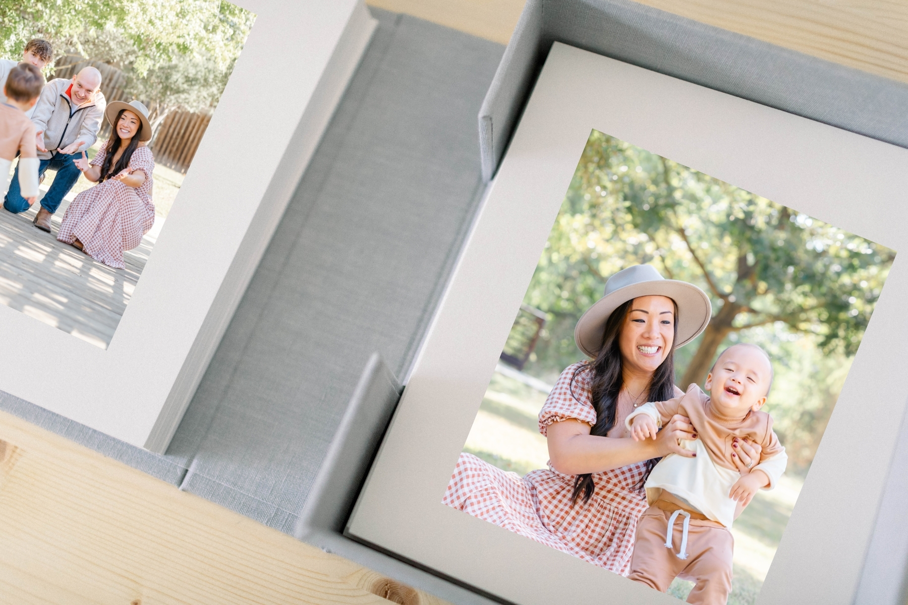 photo of a grey linen box with two matted prints. The photo in the prints show a mom and her baby boy sitting in a park laughing together. The other photo is of the family opening their arms up as the little boy runs toward them. The photos were candidly captured by an Austin TX Photographer.