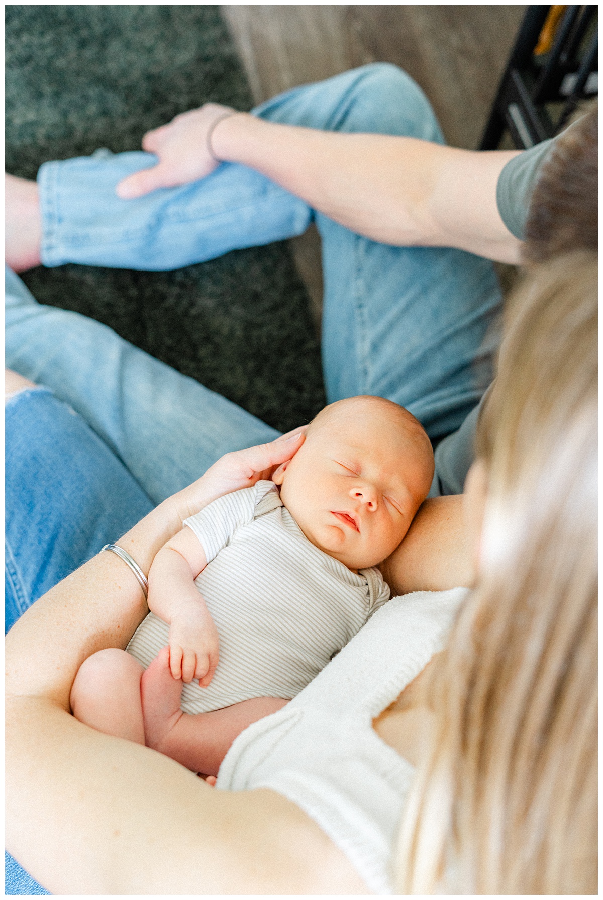 A newborn baby rests in his mothers arms in this shot captured by an in-home newborn photographer in Georgetown, TX