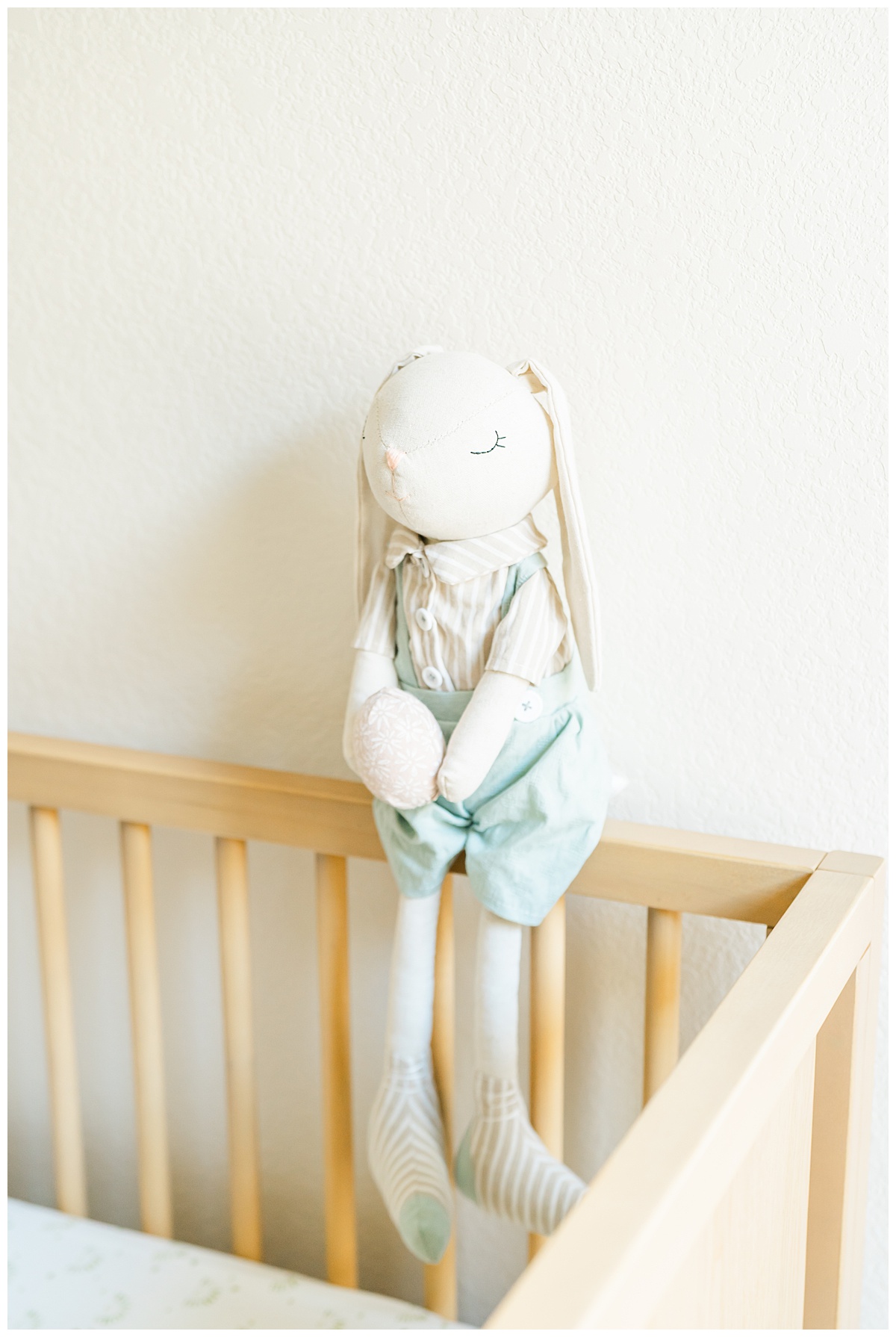 a stuffed bunny sits on the crib rail in a nursery in Leander, TX.
