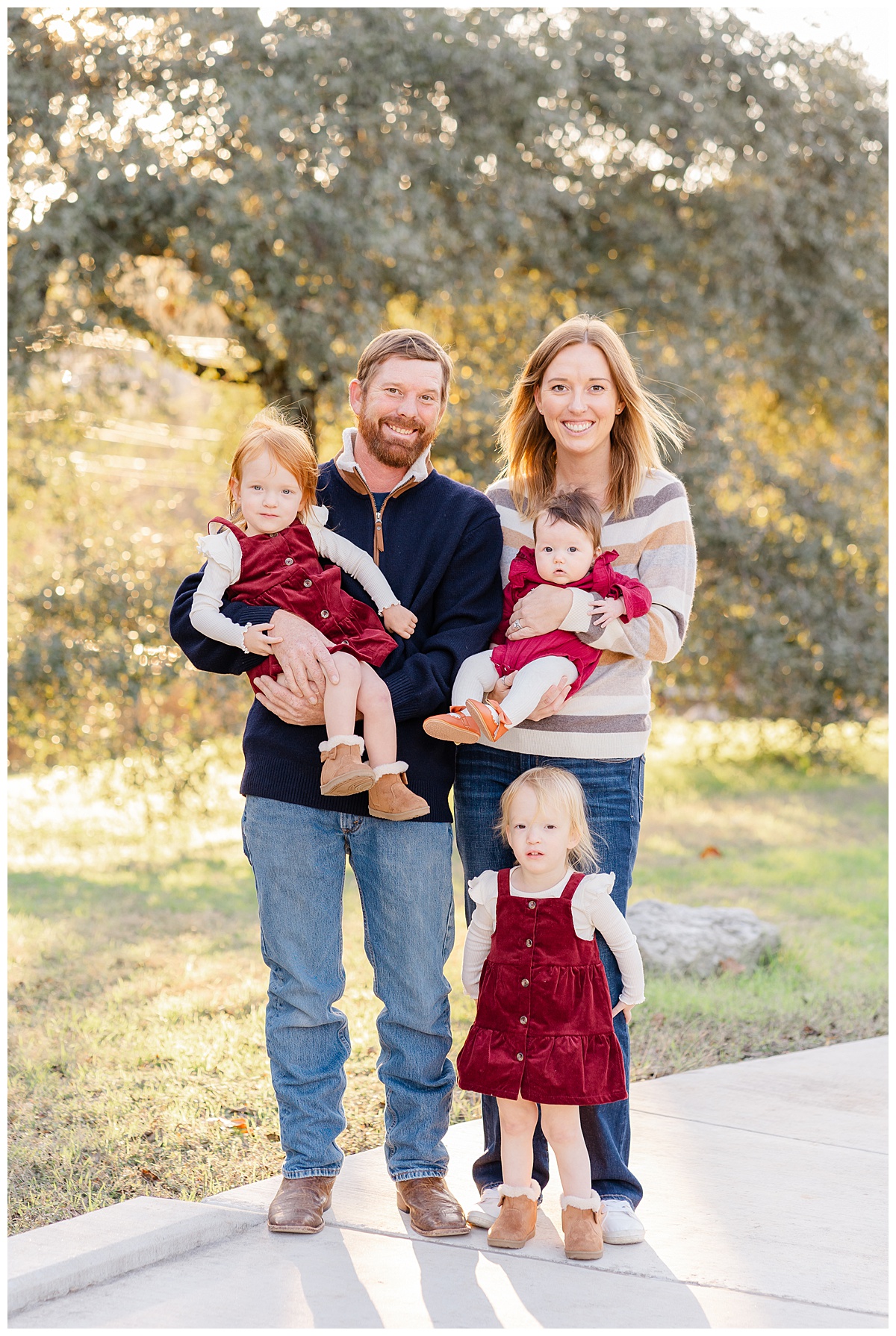 A family of 5 stands on a path at Bull Creek District Park for their Fall Family Pictures, captured by an Austin Family Photographer.