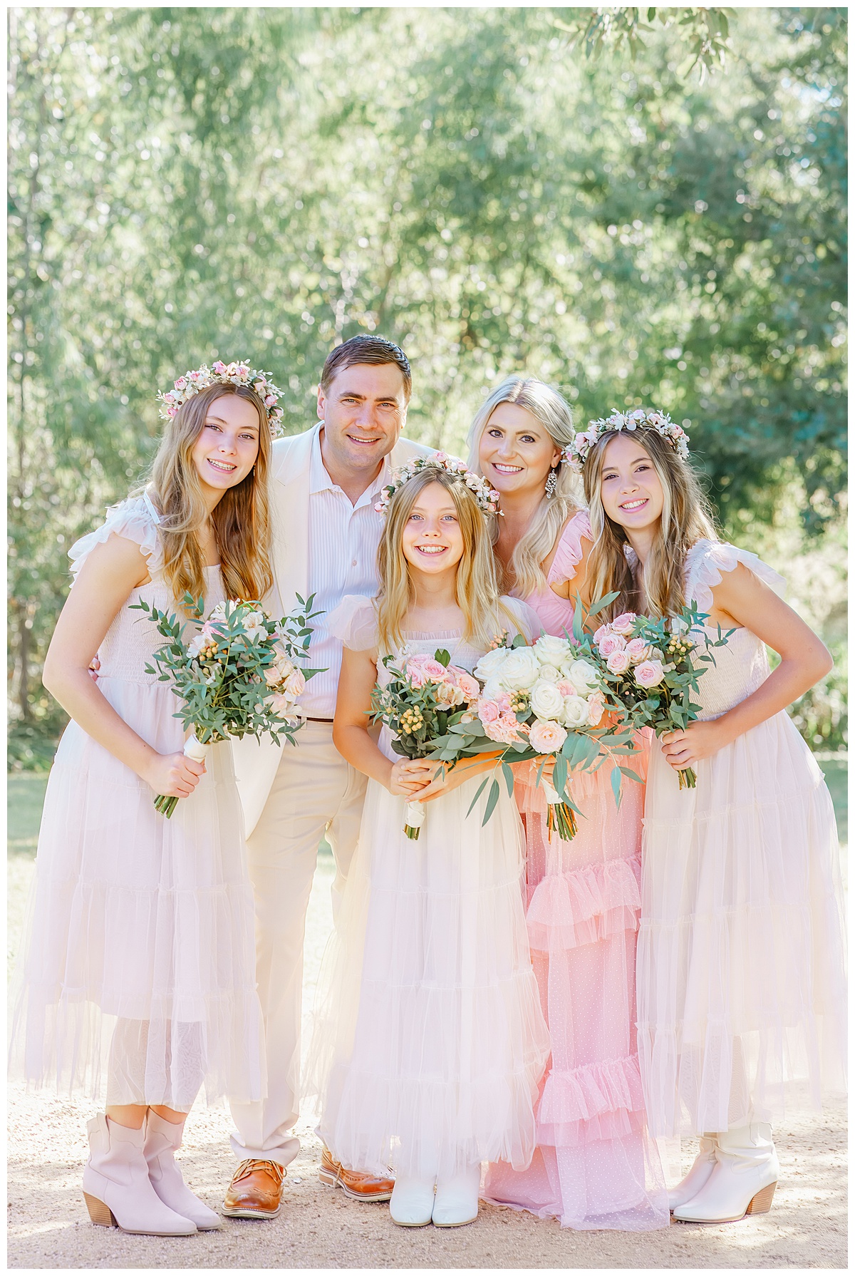 A family with three teenage girls stand together at Katherine Fleischer park and smile for their Austin family photos in celebration of an anniversary.
