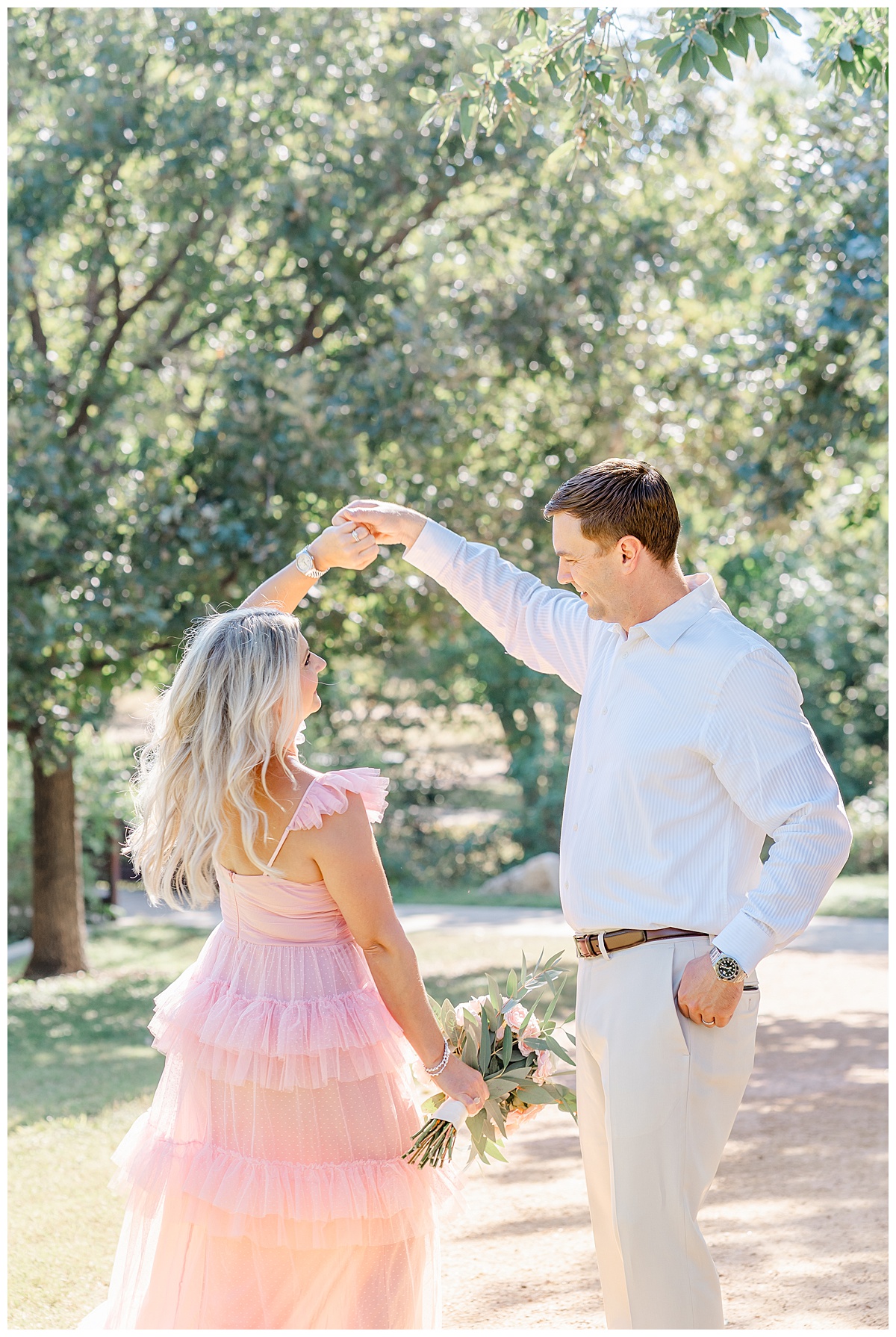 a couples with a woman dressed in a tulle pink dress dance under a tree at Katherine Fleischer Park.
