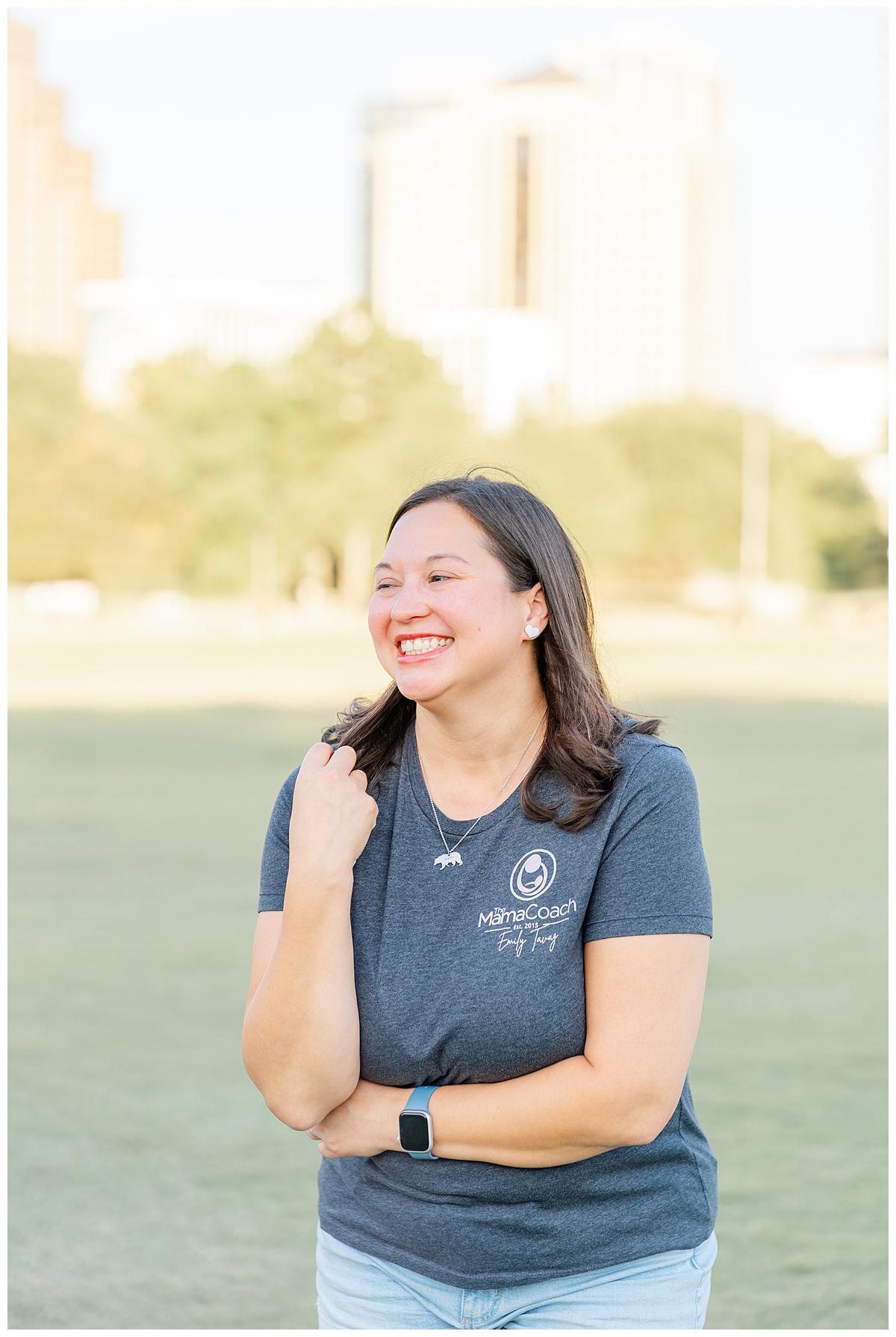 a woman candidly smiles and looks away in this candid headshot taken at Butler Metro Park in Austin, TX.