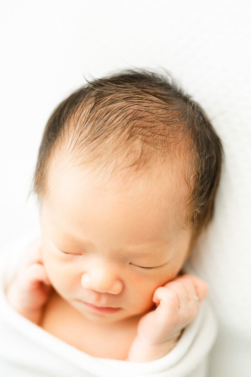 Newborn photographer in Austin captures an infant's hair in a close-up photo.